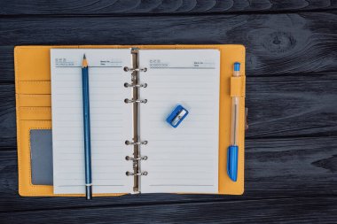 top view yellow notebook on a paper clip on a yellow background. High quality photo