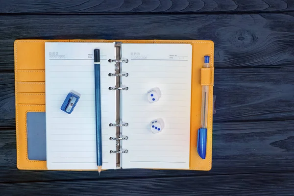 top view yellow notebook on a paper clip. on a wooden background