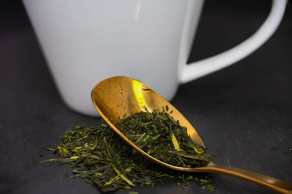 Weiße Tasse Mit Einem Goldenen Löffel Auf Dem Tee Blätter — Stockfoto