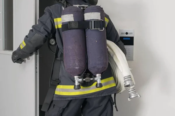 Yangın Söndürme Ekipmanlarıyla Bir Itfaiyeci Demir Kapıdan Girer — Stok fotoğraf