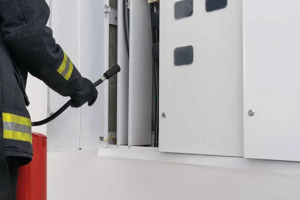 Ein Feuerwehrmann Löscht Die Elektrischen Leitungen Schaltschrank Eines Wohnhauses Seitenansicht — Stockfoto