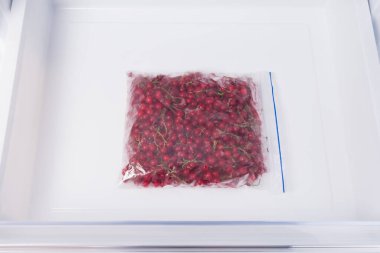 Buzdolabında kırmızı böğürtlenli bir paket var.