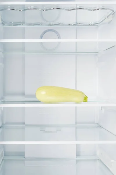 zucchini on a glass shelf in the refrigerator, front view