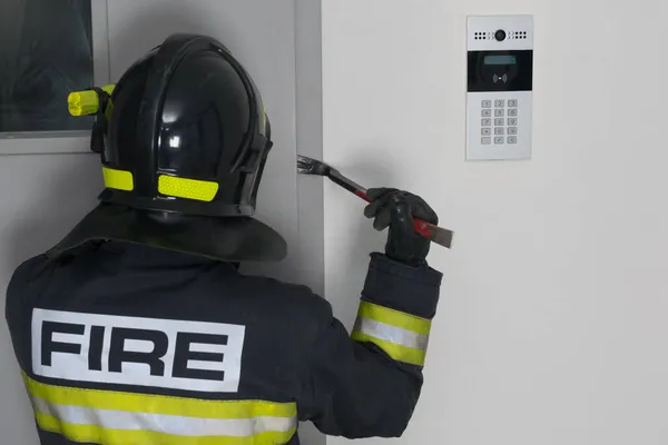 Strażak Próbuje Otworzyć Żelazne Drzwi Wejściowe Przy Wejściu Łomem Zbliżeniem — Zdjęcie stockowe