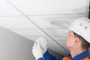 Yangın alarmı bakımı uzmanı, ikametgah sektöründe teftiş yapıyor, yazıtlar için bir yer var.