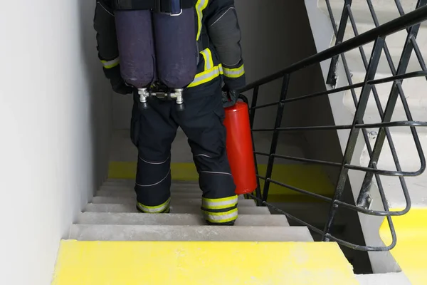 Visão Traseira Bombeiro Que Desce Com Extintor Longo Das Escadas — Fotografia de Stock