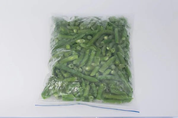 在一个白色的背景 特写的 冷冻的蚕豆 在一个食物储存袋中 — 图库照片