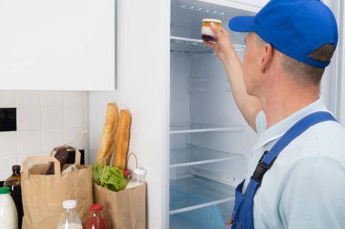 Bir market teslimatçısı bunları buzdolabına koyar.