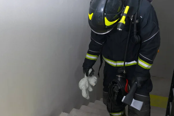 Пожежник Піднімається Сходах Тримаючи Плюшеву Іграшку Ведмедя Капелюх Відкриття Дверей — стокове фото