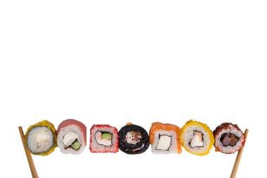 Beyaz bir masada, çeşitli Japon ekmekleri ton balığı, somon, yumuşak peynir, tempura içinde pişirilmiş ahşap çubuklar, yazıtlar için üstte bir yer var.