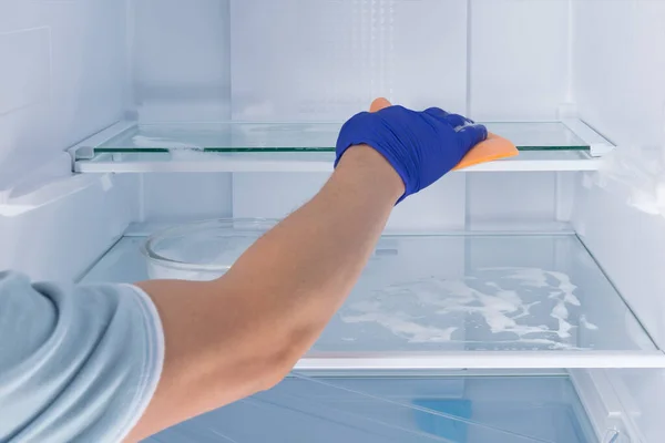 보호용 장갑을 청소부의 냉장고의 선반을 거품으로 스폰지 — 스톡 사진