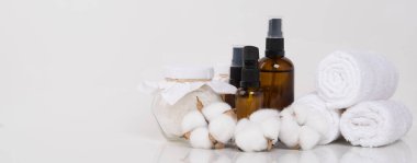 Beyaz bir arka planda, rulo havlular masaj için aromatik yağlar ve cam bir kavanozda banyo tuzu, yazıtlar için bir yer var.