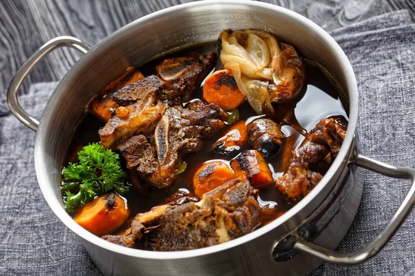 牛肉肉汤 骨头上的牛肉肉汤 慢火煮蔬菜 胡萝卜 大蒜和调味品 放在锅里 — 图库照片