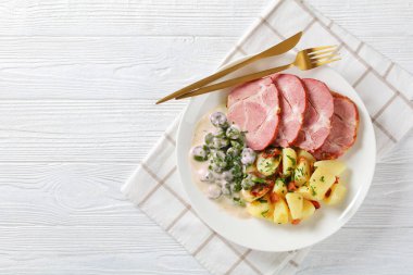 Judd mat gaardebounen, Smoked pork neck with blanched young Fava Beans cooked with creamy sauce and boiled potatoes on a white plate, classic Luxembourg dish, horizontal view, flat lay, free space clipart