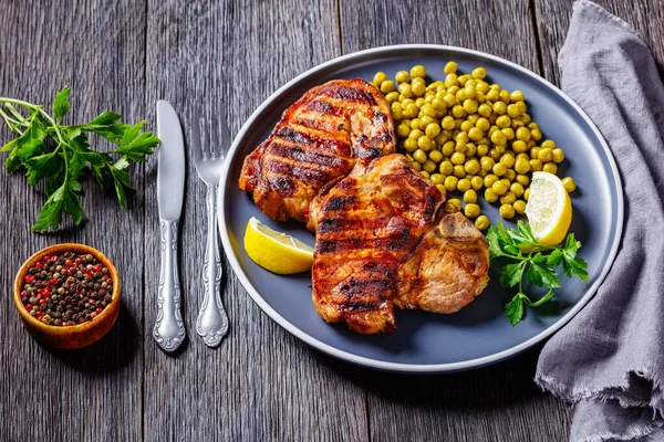 Bifes Carne Porco Grelhados Com Ervilhas Verdes Cozidas Limão Placa — Fotografia de Stock