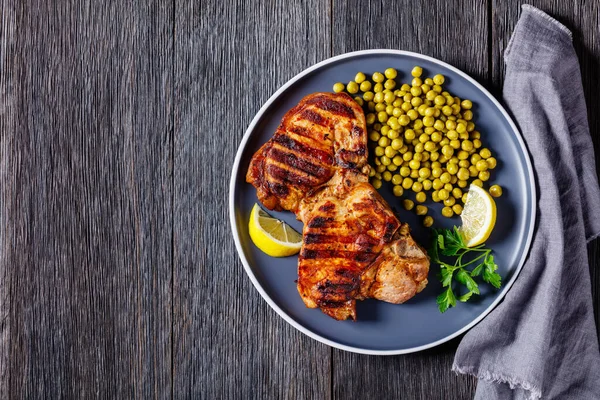 Saftiga Grillade Fläskkotletter Med Kokta Gröna Ärtor Och Citron Tallrik — Stockfoto