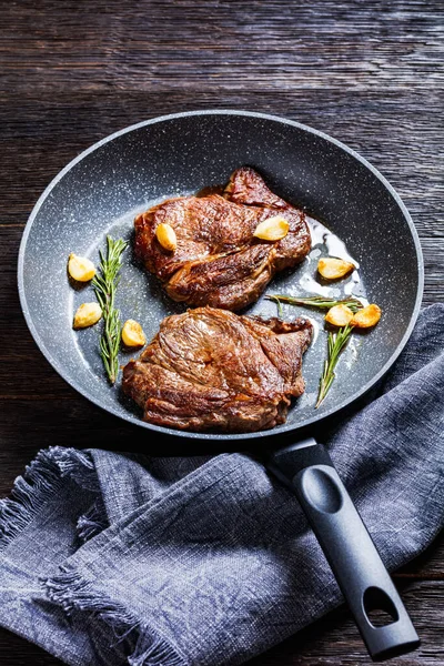 Koyu Ahşap Bir Masada Tavada Kızartılmış Sarımsaklı Biftek Biberiye Dikey — Stok fotoğraf
