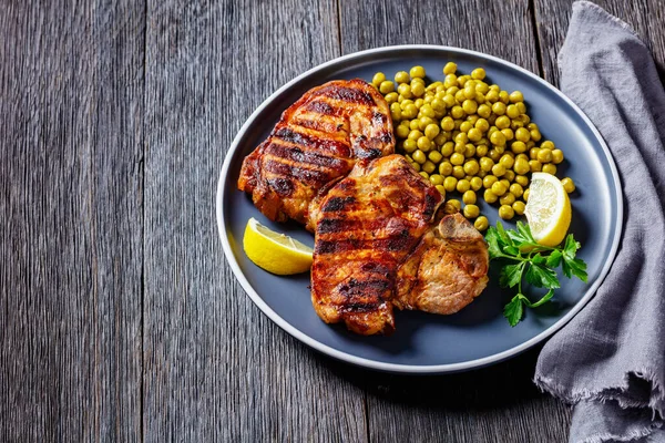 Grillade Fläskkotletter Med Kokta Gröna Ärtor Och Citron Tallriken Ett — Stockfoto