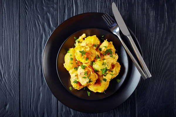 Baked Baby Potatoes Cheesy Mornay Sauce Black Plate Silver Cutlery — Stock Photo, Image