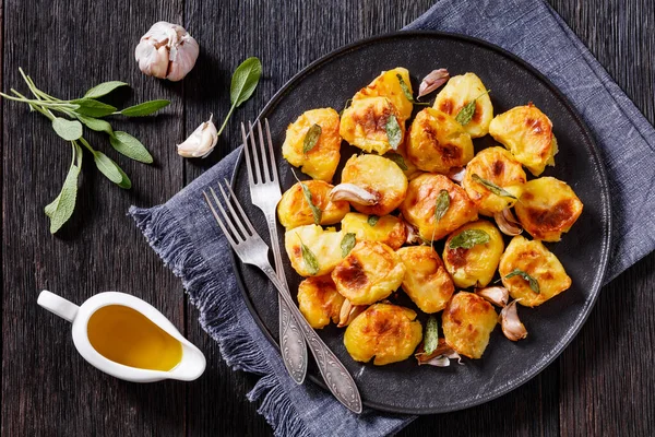 Crispy Roasted Squashed Potatoes Garlic Sage Leaves Black Plate Wooden — Stock Photo, Image