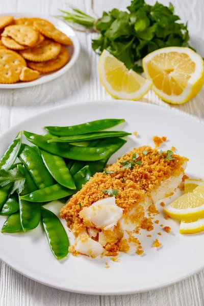 Baked Haddock Crackers Butter Toppings Served Boiled Snow Peas Lemon — стоковое фото