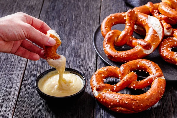 Woman Dips Piece Pretzel Cheese Sauce Horizontal View Close — Zdjęcie stockowe