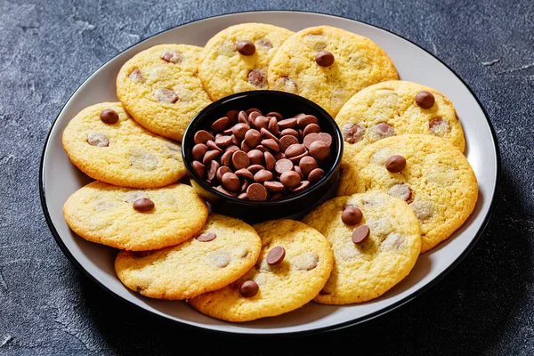 chocolate chip lemon yellow cookies on  plate on grey table, american cuisine, landscape view from above