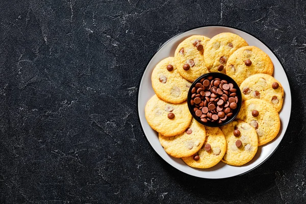 chocolate chip lemon yellow cookies on  plate on grey table, american cuisine, horizontal view from above, flat lay, free space