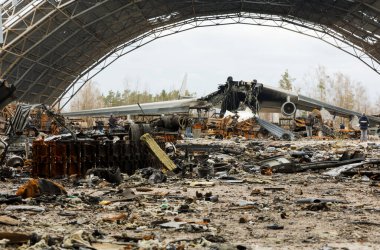 Hostomel, Ukrayna. Rusya 'nın Ukrayna işgali sırasında Hostomel havaalanında imha edilen Mriya AN-225' in arka planındaki Rus zırhlı araçlarının kalıntıları.
