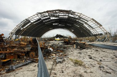 Hostomel, Ukrayna. Rusya 'nın Ukrayna işgali sırasında Hostomel havaalanında imha edilen Mriya AN-225' in arka planındaki Rus zırhlı araçlarının kalıntıları.