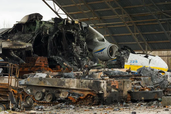 Hostomel, Ukrayna. Rusya 'nın Ukrayna işgali sırasında Hostomel havaalanında imha edilen Mriya AN-225' in arka planındaki Rus zırhlı araçlarının kalıntıları.