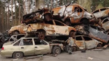 Irpin, UKRAINE 25 Nisan 2022 Yanmış sivil arabaların atılması, Rus ordusu tarafından vurulması ve Rusya 'nın Ukrayna' ya karşı savaşı sırasında yok edilmesi