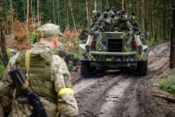 BUCHA, UKRAINE - JULY 13, 2022: Fighter of the Bucha territorial defense on a captured russian armored car during tactical exercises