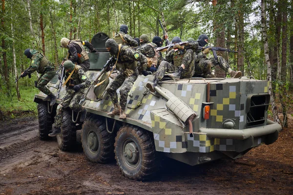 BUCHA, UKRAINE - JULY 13, 2022: Fighter of the Bucha territorial defense on a captured russian armored car during tactical exercises