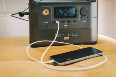 KAUNAS, LITHUANIA - 23 Eylül 2022: Ecoflow River Taşınabilir Enerji İstasyonu ile iPhone 13 Pro Max şarj ediliyor