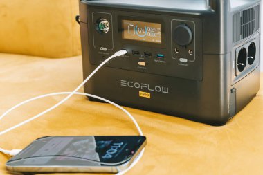 KAUNAS, LITHUANIA - 23 Eylül 2022: Ecoflow River Taşınabilir Enerji İstasyonu ile iPhone 13 Pro Max şarj ediliyor