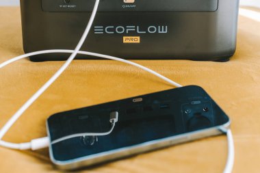 KAUNAS, LITHUANIA - 23 Eylül 2022: Ecoflow River Taşınabilir Enerji İstasyonu ile iPhone 13 Pro Max şarj ediliyor