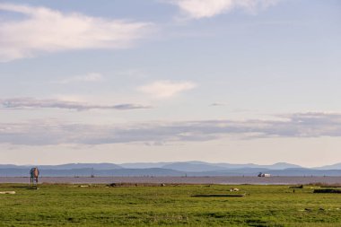 Sturgeon Banks Doğal Gün batımı Gökyüzü ve arkasında dağlar olan bulutlar.