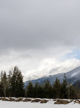 Dağlar ve bulutlarla dolu karamsar bir manzara.