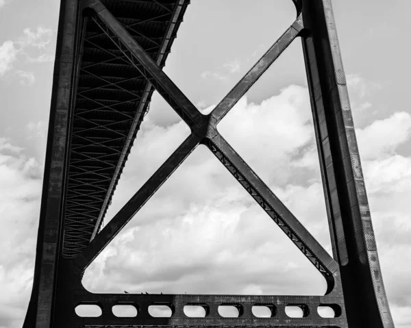 siyah ve beyaz çelik köprü bulutlu gökyüzüne karşı metal elementi kapat.