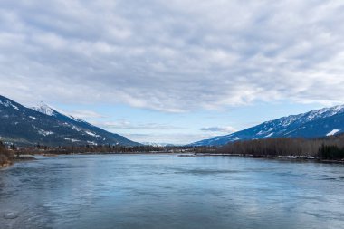 Dağlarda karla kaplı geniş Kolombiya nehri mavi gökyüzü İngiliz Kolombiyası Kanada ilkbaharı.
