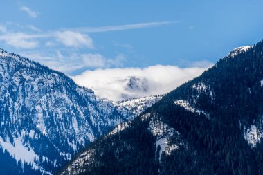Büyük dağlar karla kaplı ve bulutlu güneşli gökyüzü Britanya Kolombiyası Kanada