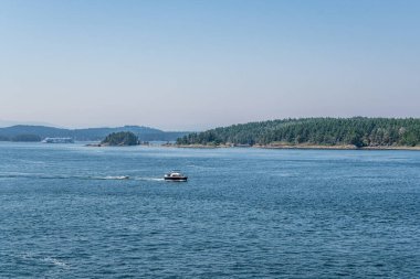 VANCOUVER, Kanada - 29 Haziran 2021: Gürcistan Boğazı, sudaki yeşil orman motorlu teknesiyle kaplı adalar kıyısı.