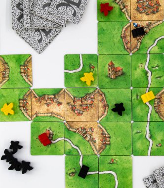 Carcassonne masa oyunu sarı, siyah ve kırmızı meepllerle oynadı