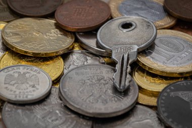 Dünyanın farklı ülkelerindeki madeni paraların arka planında anahtar