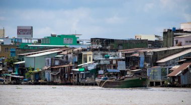 VINH LONG, VİETNAM - 26 Nisan 2018: Mekong Deltası 'ndaki liman köyü ve kargo gemisi