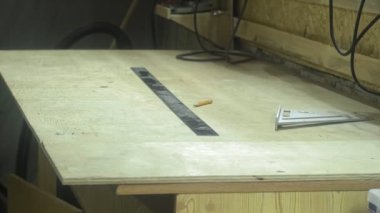 Marangozluk atölyesindeki bir adam malzemeyi cetvelle ölçer, atölye atölyesi mobilya üretimi yapar..