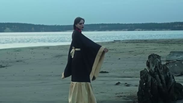 川岸では伝統的な着物姿の女性が踊ります。奇妙な手の動き. — ストック動画