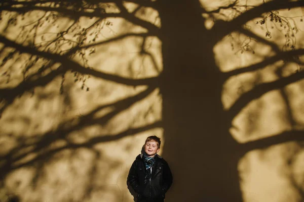 Niño en gran sombra de árbol en la pared —  Fotos de Stock