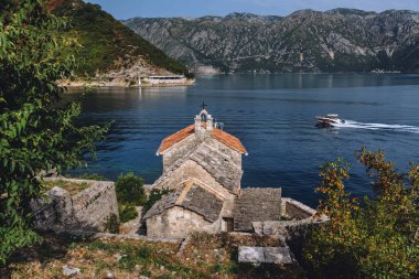 Gospa od Andjela church with its lighthouse in the most narrow part of the Boka Bay - Verige Strait. Medieval stone church is popular destination for nautical and cruise tourism in the Bay of Kotor.
